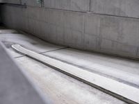 a skateboarder is in a concrete parking garage space riding down a road and looking at the ground