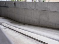a skateboarder is in a concrete parking garage space riding down a road and looking at the ground