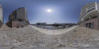 360 view of a cobblestone sidewalk on a sunny day at the harbor area of a modern residential development