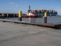 a harbor with cargo trucks parked beside it and one being unloaded by a boat