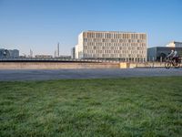 this grass field has been cut short to cover the area in the distance, and it is a grassy area next to an old building