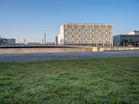 this grass field has been cut short to cover the area in the distance, and it is a grassy area next to an old building