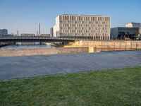 this grass field has been cut short to cover the area in the distance, and it is a grassy area next to an old building