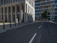 the empty street with bicycles parked in front of the buildings has a sign that says the library on it