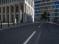 the empty street with bicycles parked in front of the buildings has a sign that says the library on it