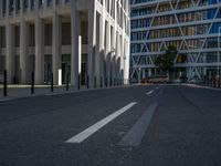 the empty street with bicycles parked in front of the buildings has a sign that says the library on it