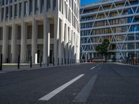 the empty street with bicycles parked in front of the buildings has a sign that says the library on it