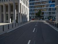 the empty street with bicycles parked in front of the buildings has a sign that says the library on it