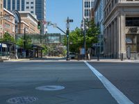 an empty street with buildings and parked cars on the sidewalks and green lanes on the sidewalk