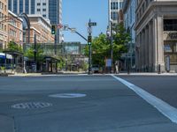 an empty street with buildings and parked cars on the sidewalks and green lanes on the sidewalk