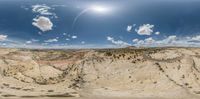 a large open area with many different types of rock and dirt under a partly cloudy blue sky