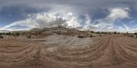 a landscape photo with a very cloudy sky behind it that has many curves of dirt on the ground