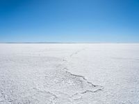 footprints are in the sand on the shore of a lake or water, making the shape of a heart