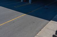 an empty parking lot with no cars on the ground and two people standing underneath it