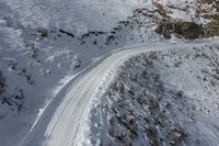 a person on skis traveling up the side of a snowy hill in the mountains