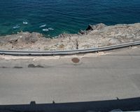 a paved road beside some large boats and a bridge with a bridge to the water