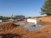 a picture of a building being built on a field near a forest in the background