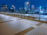 people standing on a subway platform with many buildings in the background at night light in tokyo