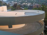 the view of a residential area with a circular balcony and a parking lot next to it