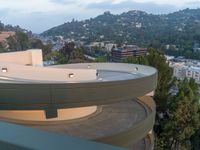 the view of a residential area with a circular balcony and a parking lot next to it