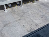 two parked vehicles sitting in the middle of a parking garage lot with a ramp going up