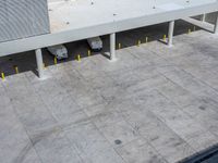 two parked vehicles sitting in the middle of a parking garage lot with a ramp going up