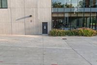 a woman riding a bike past an office building with windows and grass around it in front of a fire hydrant