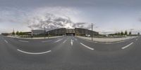 a fish eye view of an intersection with a high rise building in the background,