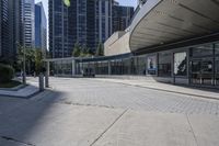 a person sitting at the bench in front of a mall that is empty of people