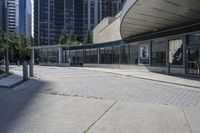 a person sitting at the bench in front of a mall that is empty of people