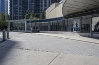 a person sitting at the bench in front of a mall that is empty of people