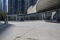 a person sitting at the bench in front of a mall that is empty of people