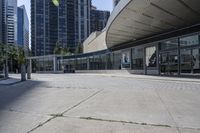 a person sitting at the bench in front of a mall that is empty of people