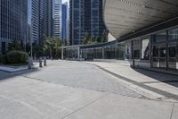 a person sitting at the bench in front of a mall that is empty of people