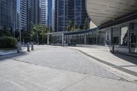 a person sitting at the bench in front of a mall that is empty of people