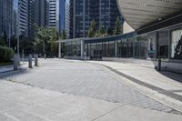 a person sitting at the bench in front of a mall that is empty of people