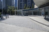 a person sitting at the bench in front of a mall that is empty of people