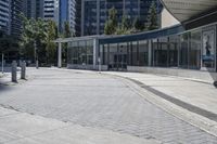 a person sitting at the bench in front of a mall that is empty of people