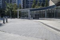 a person sitting at the bench in front of a mall that is empty of people