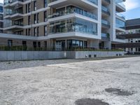 an empty parking lot with a building behind it, with an apartment building to the left