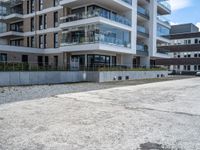 an empty parking lot with a building behind it, with an apartment building to the left