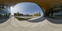 a 360 - view photograph of a large building with a circular mirror view in a courtyard