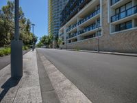 a deserted road next to tall buildings with no traffic signs on it in a city street