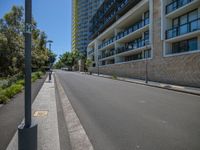 a deserted road next to tall buildings with no traffic signs on it in a city street