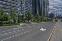 the road in front of a big building that is surrounded by tall buildings and a very nice