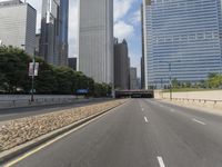 an empty street in front of some very high rise buildings, and there's also a railroad with a train on the track