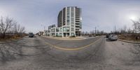 a curved view looking at a high rise condom building in an urban area, with no traffic