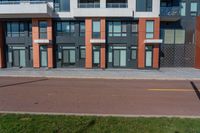 there are several apartments with windows on the building above them in this view from the sidewalk