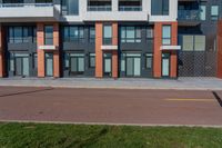 there are several apartments with windows on the building above them in this view from the sidewalk