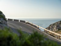 the road to the ocean along the cliffs by the ocean is empty and there are cars on both sides